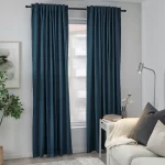 Dark blue blackout curtains hanging on a curtain rod in a living room