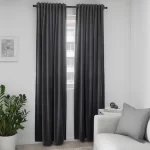 Room darkening curtains in a dark gray color hanging on a window