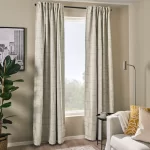 Two blackout curtains hanging on a window, blocking out light