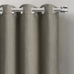 gray blackout curtain with silver grommets hanging on a silver curtain rod