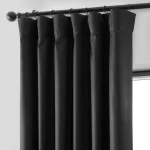 pleated black curtains hanging from a dark metal curtain rod. The fabric appears thick and smooth