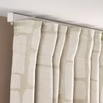 pleated blackout curtains hanging from a white ceiling track